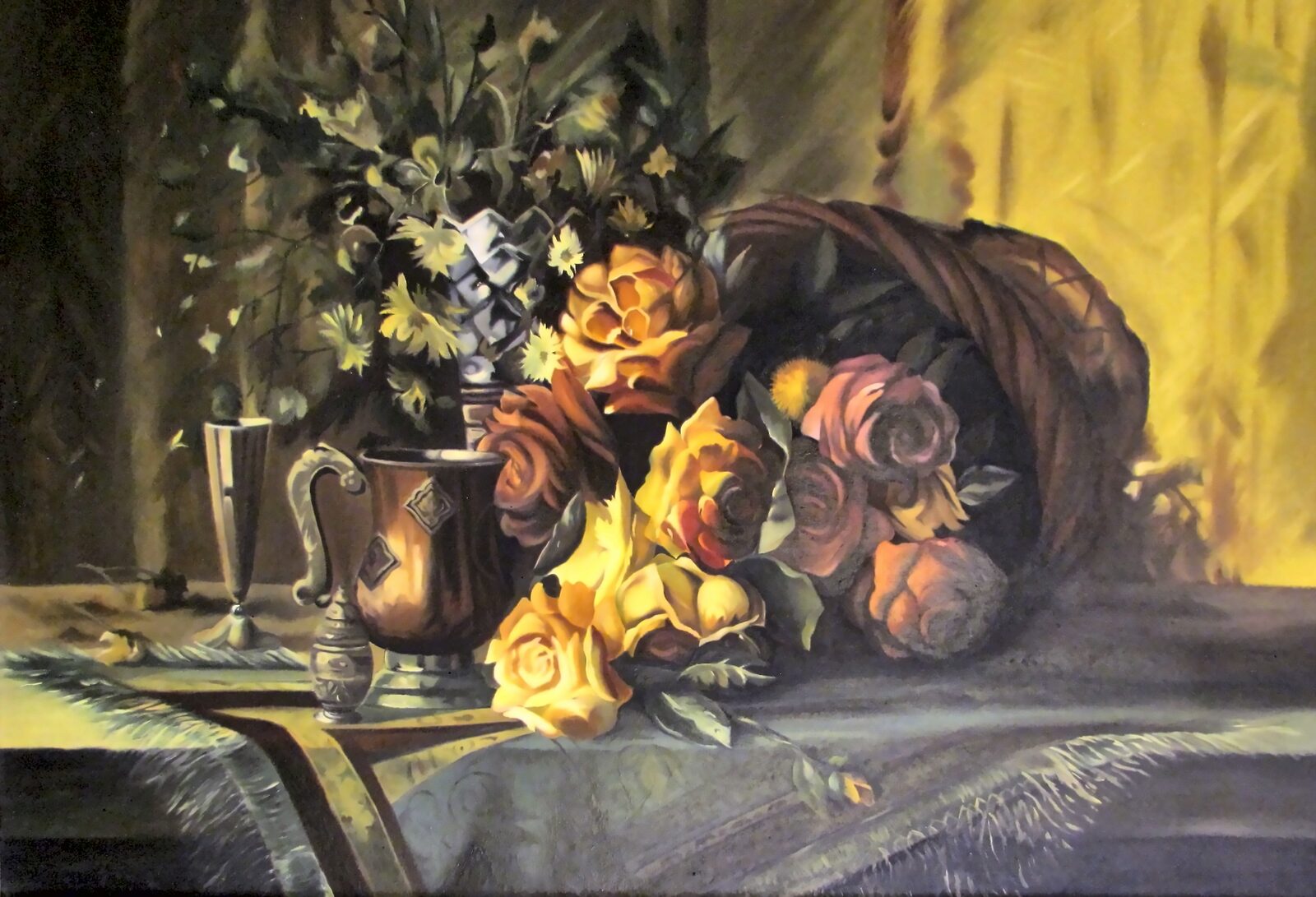Amber, coral and pink roses spill from a tipped wicker horn beside a pewter jug and goblet, in front of a glowing gold curtain.